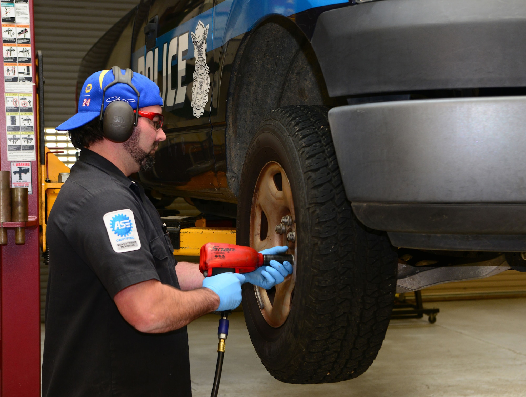 Bart Hicks, 9th Support Division vehicle maintenance work leader removes a tire from a police vehicle