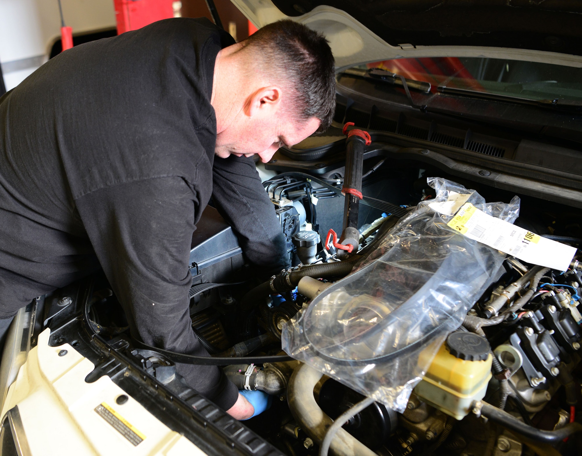 Michael Brink, 9th Support Division automotive mechanic, changes an air conditioning bracket in a chase car