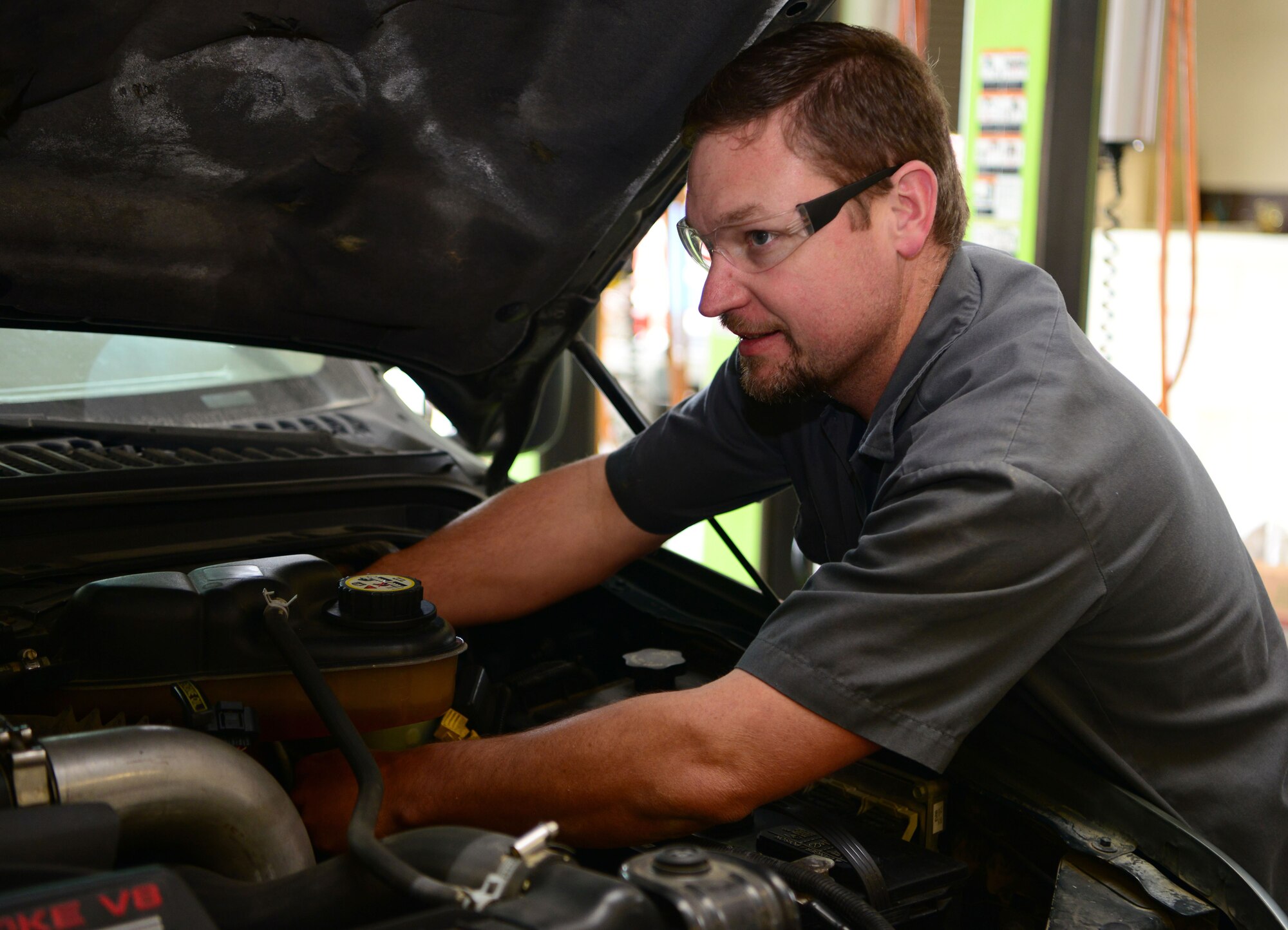 Jesse McManis, 9th Support Division heavy mobile equipment mechanic, replaces a master cylinder