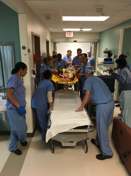 A team of medical professionals are working together to administer emergency medical care for a simulated patient in the 88th Medical Group simulation center. Simulating training allows students to transfer what they have learned in the simulated center to real life medical scenarios.