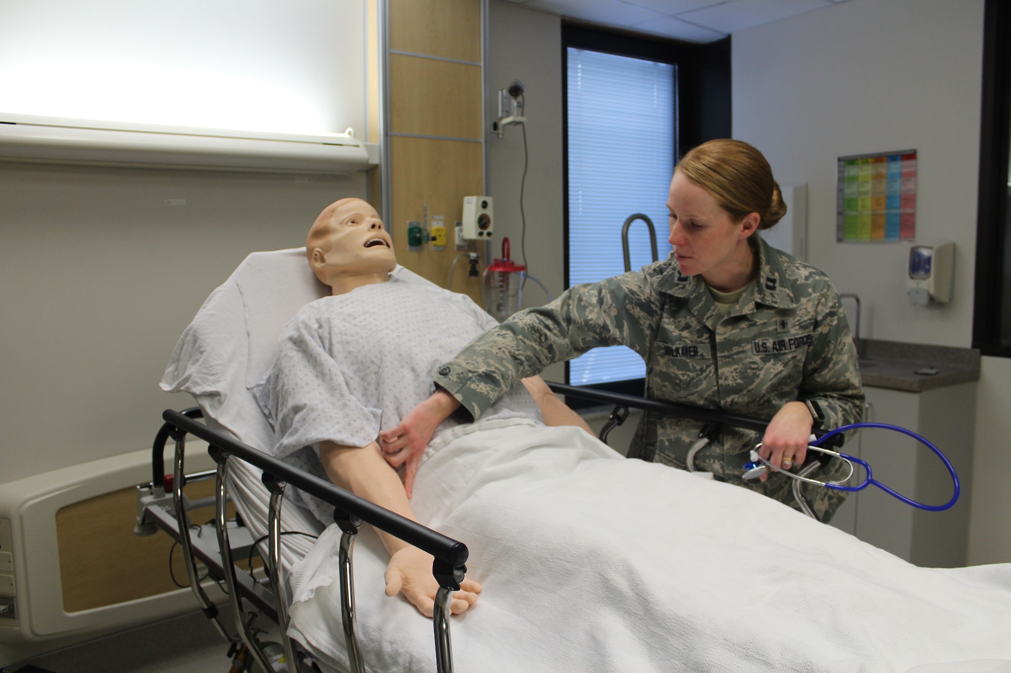 Capt. Catherine Volkmer, 88th Medical Group sustainment medical and readiness trained program manager, checks the vital signs on the simulated patient. The mannequins can be programmed to exhibit various vital signs tailored to the type of training. (U.S. Air Force Photo/Stacey Geiger)