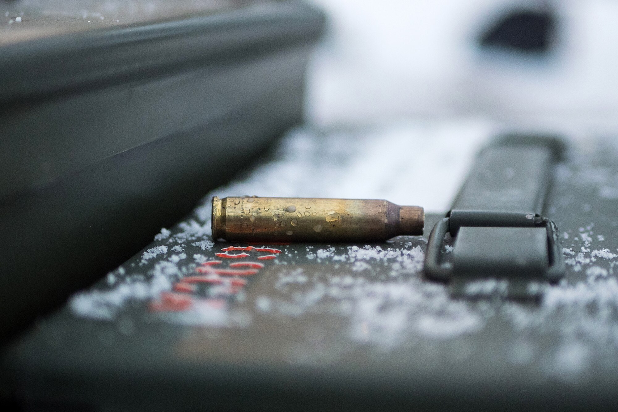 An expended 5.56mm casing rests on an ammunition can as Airmen assigned to the 673d Security Forces Squadron conduct an M249 Squad Automatic Weapon, and M2 .50 Caliber machine gun qualification range on Joint Base Elmendorf-Richardson, Alaska, Jan. 10, 2018. Security Forces Airmen perform extensive training in law enforcement as well as combat tactics to protect U.S. Military bases and assets both stateside and overseas.