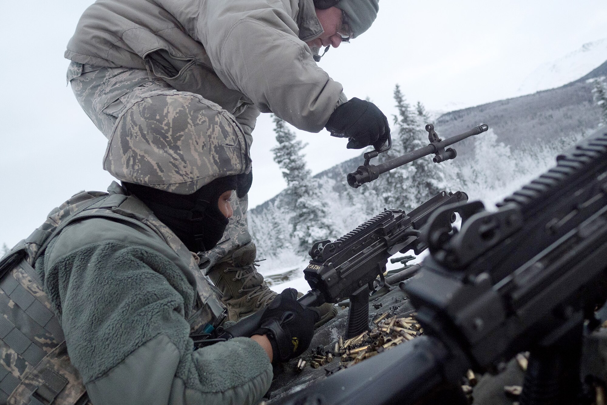 Senior Airman Cody Morgan, a native of New Salisbury, Ind., removes the barrel of an M249 Squad Automatic Weapon for Airman 1st Class Kaylon Thomas, a native of Conway, Ark., as Airmen assigned to the 673d Security Forces Squadron conduct machine gun qualification range on Joint Base Elmendorf-Richardson, Alaska, Jan. 10, 2018. Security Forces Airmen perform extensive training in law enforcement as well as combat tactics to protect U.S. Military bases and assets both stateside and overseas.