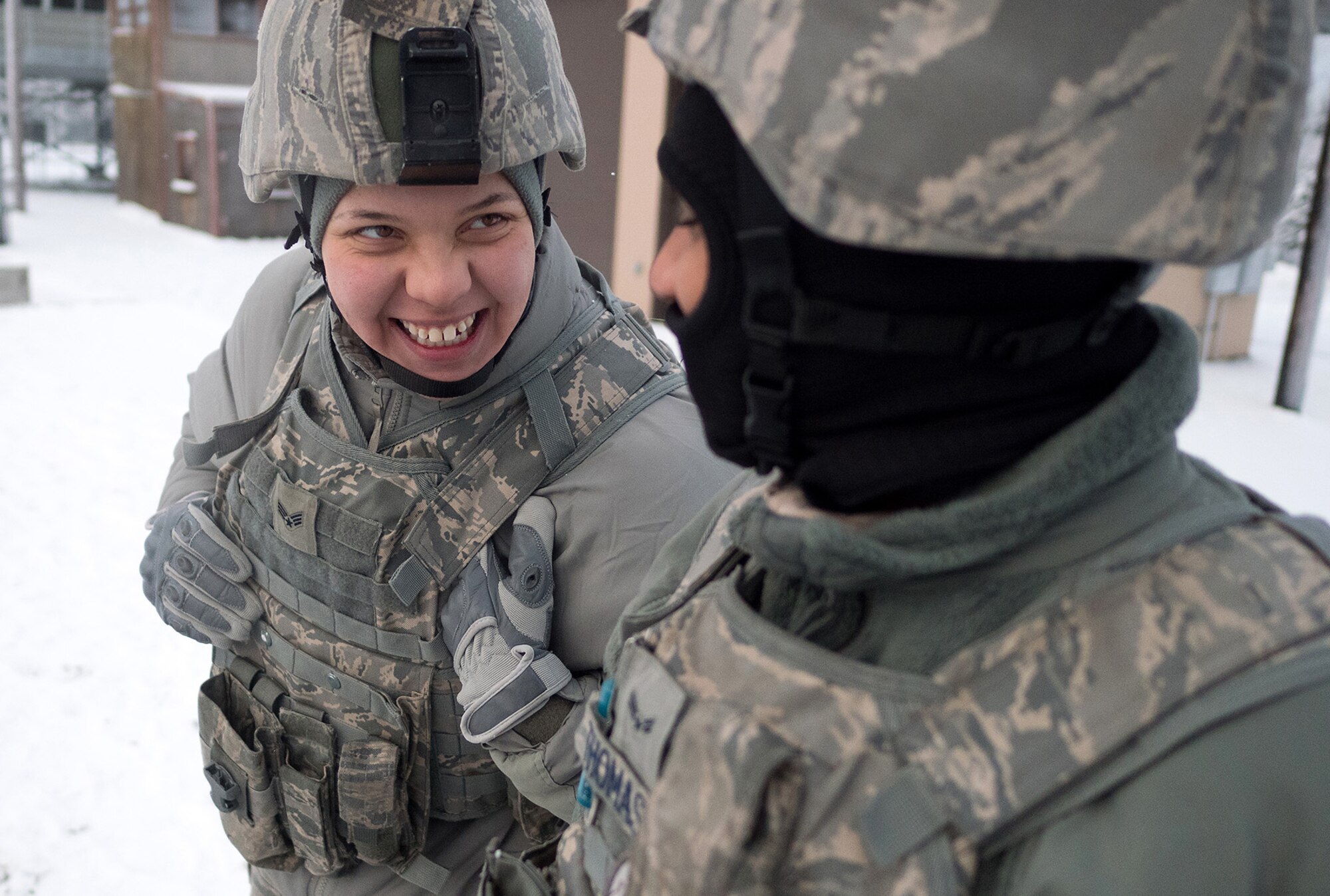 Senior Airman Tina-Louise Dunbar, a native of Anchorage, Alaska, left, and Airman 1st Class Kaylon Thomas, a native of Conway, Ark., both assigned to the 673d Security Forces Squadron, share a laugh on the gun line during a machine gun qualification range on Joint Base Elmendorf-Richardson, Alaska, Jan. 10, 2018. Security Forces Airmen perform extensive training in law enforcement as well as combat tactics to protect U.S. Military bases and assets both stateside and overseas.