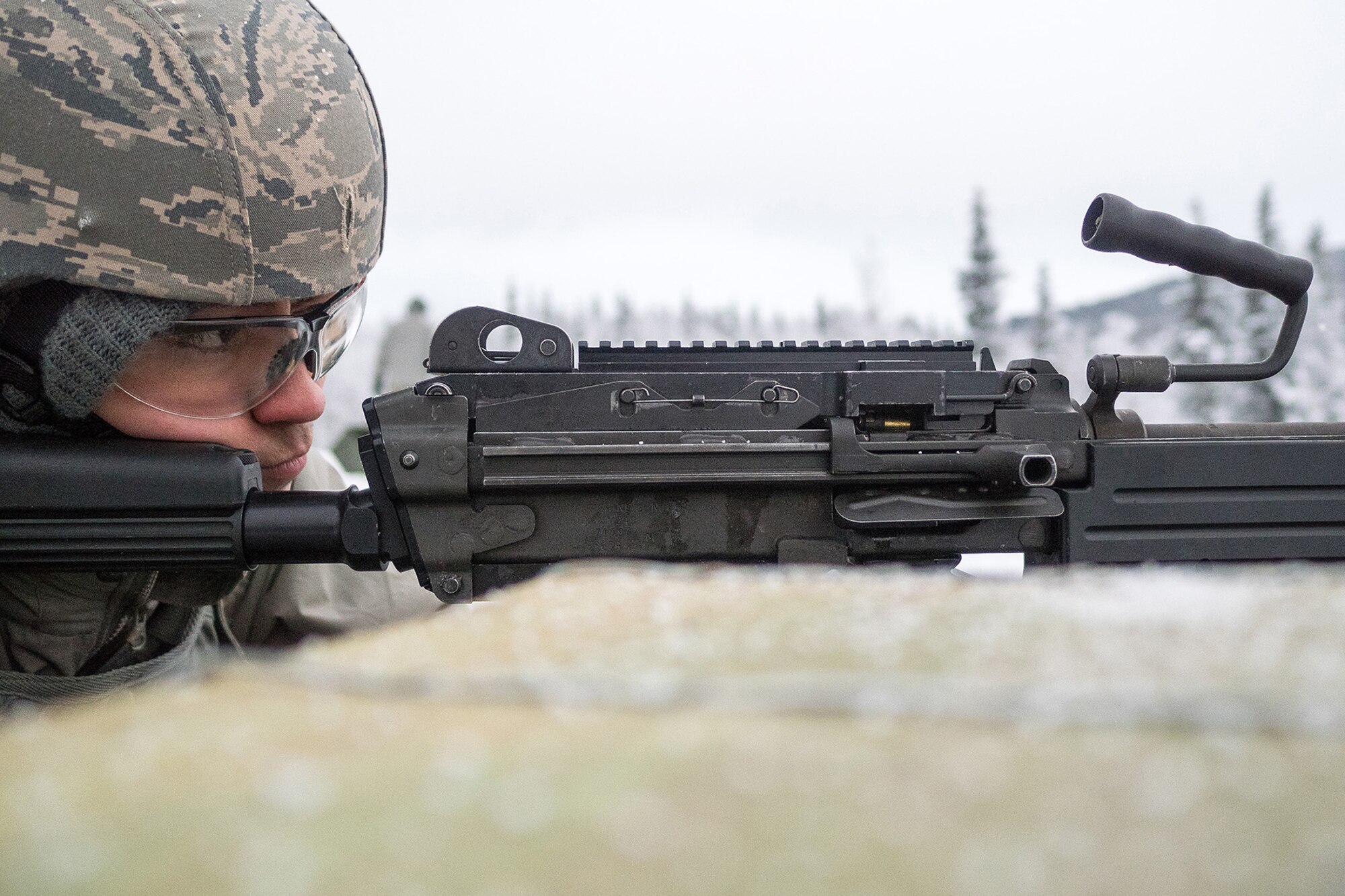 An Airman assigned to the 673d Security Forces Squadron lines up a traget with an M249 Squad Automatic Weapon during machine gun qualification range on Joint Base Elmendorf-Richardson, Alaska, Jan. 10, 2018. Security Forces Airmen perform extensive training in law enforcement as well as combat tactics to protect U.S. Military bases and assets both stateside and overseas.
