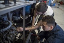 Airman 1st Class Cody Noel, 374th Maintenance Squadron aerospace ground equipment technician, teaches a fellow AGE Airman about how to properly fix a piece of equipment, Jan. 10, 2018, at Yokota Air Base, Japan.