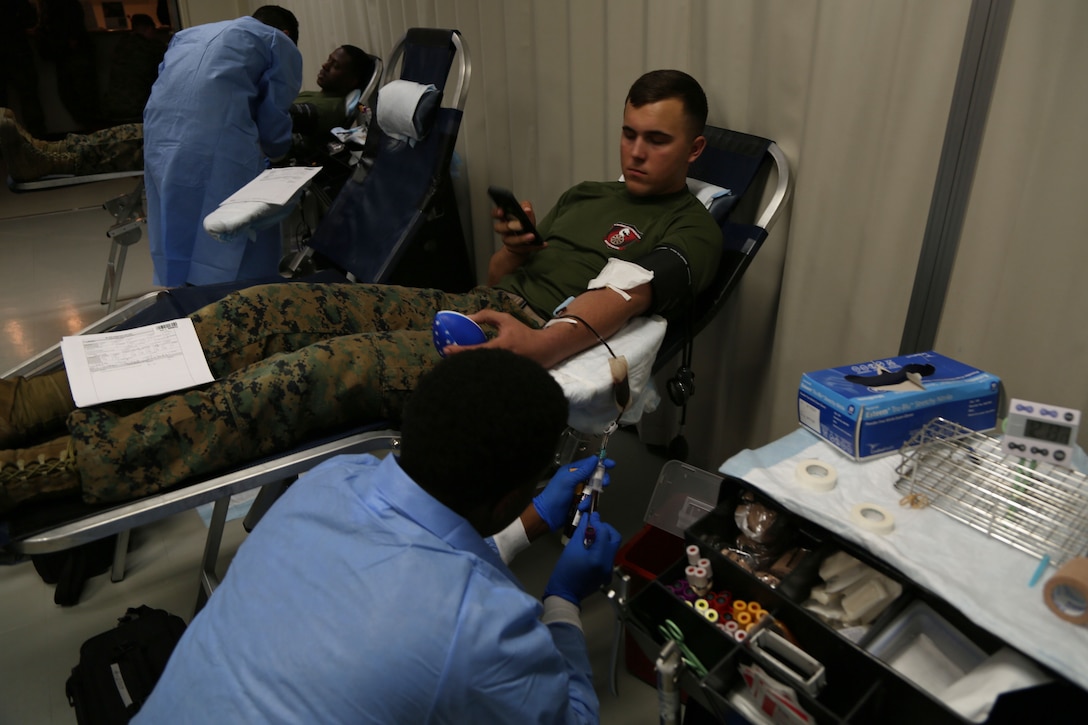 CAMP FOSTER, OKINAWA, Japan – Pfc. Isriah Senel watches the lab technician take samples of his blood Jan. 11 at the Single Marine Program blood drive aboard Camp Foster, Okinawa, Japan.