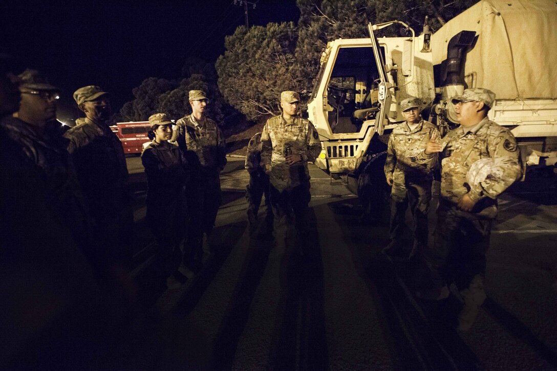 Army Staff Sgt. Michael Aguilar, right, briefs soldiers on the mission to soldiers.