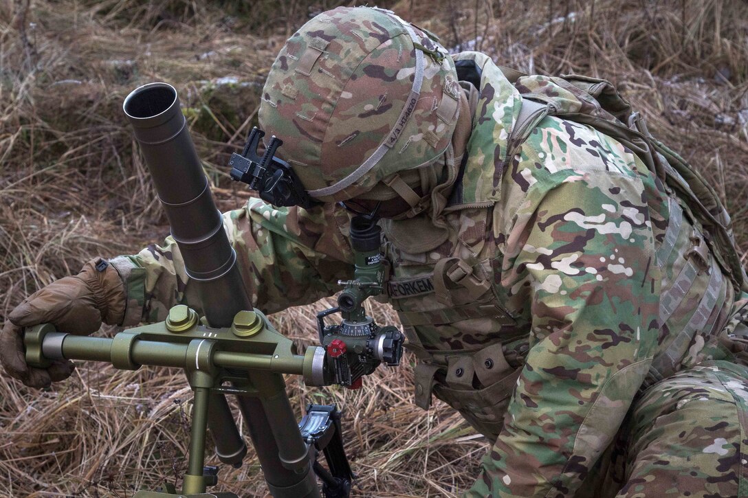 Army Spc. Hiram Tarforkem sights-in and aligns a 60-milimeter mortar during Bull Run III.