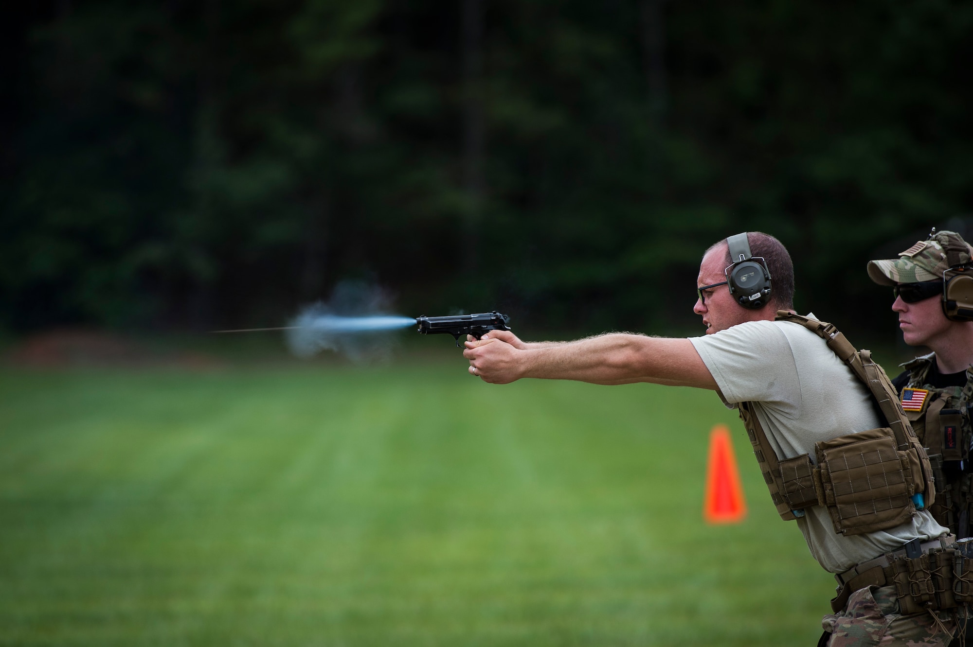 Senior Airman Ryan Green, a combat broadcaster, fires at his target while Tech. Sgt. Samuel Weaver, weapons and tactics training instructor, both assigned to the 1st Combat Camera Squadron, observes his hits during weapons and tactics training on the shooting range at Fort Jackson, S.C., June 22, 2017. The Airmen of the 1st Combat Camera Squadron constantly train for readiness to document combat operations, exercises and other contingencies from the ground and in the air. (U.S. Air Force photo by Tech. Sgt. Larry E. Reid Jr.)