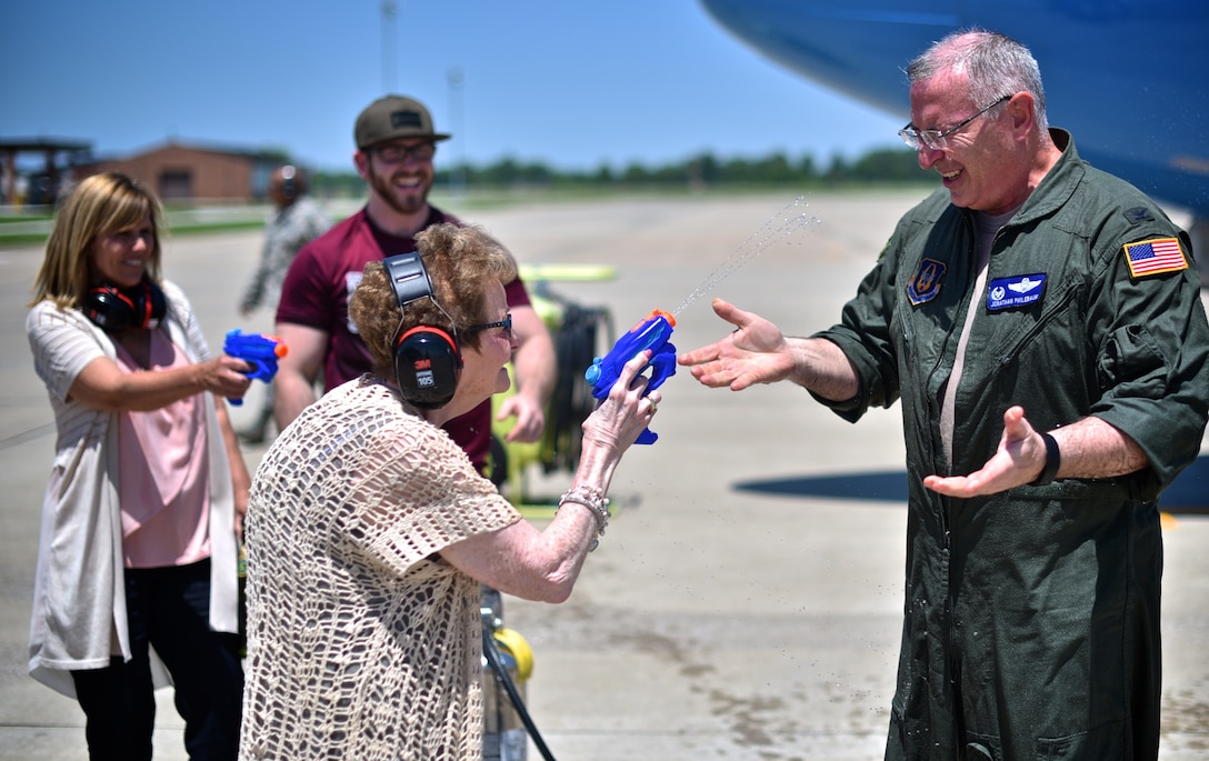 Rosalie Philebaum squirts water at her son, Col. Jonathan Philebaum, 932nd Airlift Wing commander, during his fini flight at Scott Air Force Base, Ill., May 31, 2017. Jonathan Philebaum’s wife, JoAnn Philebaum, and their son both look on with delight as he is shocked by his mother's water blasts. (U.S. Air Force photo by Christopher Parr)