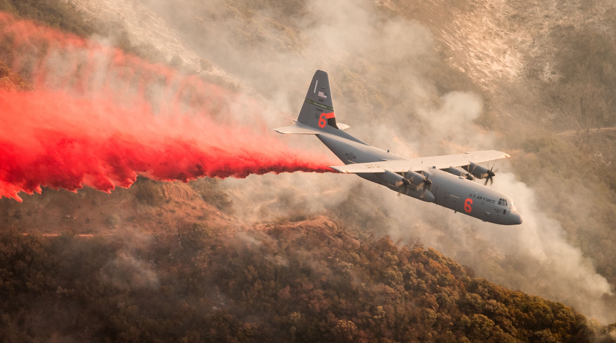 A C-130J Hercules assigned to the 146th Airlift Wing, Channel Islands Air National Guard Base, Port Hueneme, Calif., drops fire retardant chemicals onto a ridge line above Santa Barbara, Calif., Dec. 13, 2017, in an effort to contain the Thomas wildfire. (U.S. Air Force photo by J.M. Eddins Jr.)