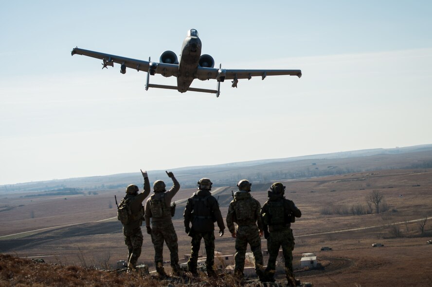 Members of the 146th Air Support Operations Squadron, from Oklahoma City, and Estonian tactical air control party specialists acknowledge a 442nd Fighter Wing A-10 Thunderbolt II from Whiteman Air Force Base, Mo., during a show of force after completing close air support training at Smoky Hill Air National Guard Range in Salina, Kan., Dec. 13, 2017. The Estonian TACPs traveled to the U.S. to work alongside members of the 146th ASOS to complete upgrade training and enhance multi-national relationships. This was the first time the 146th ASOS hosted the Estonian TACPs. (U.S. Air National Guard photo by Staff Sgt. Tyler Woodward)