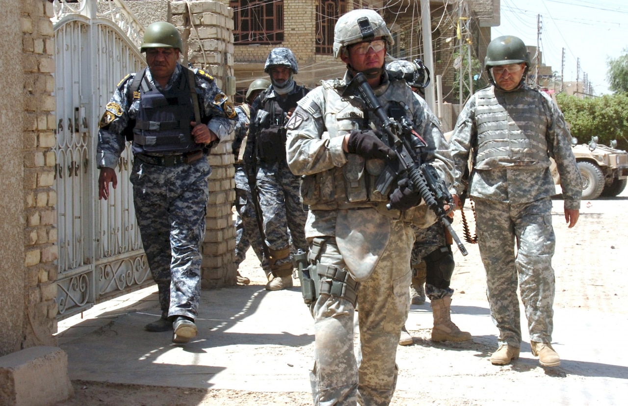 Army 1st Sgt. Henning Jensen, first sergeant of Headquarters Company, 1st Battalion, 1st Security Force Assistance Brigade, leads a foot patrol with the National Police Transition Team in eastern Baghdad in 2008.