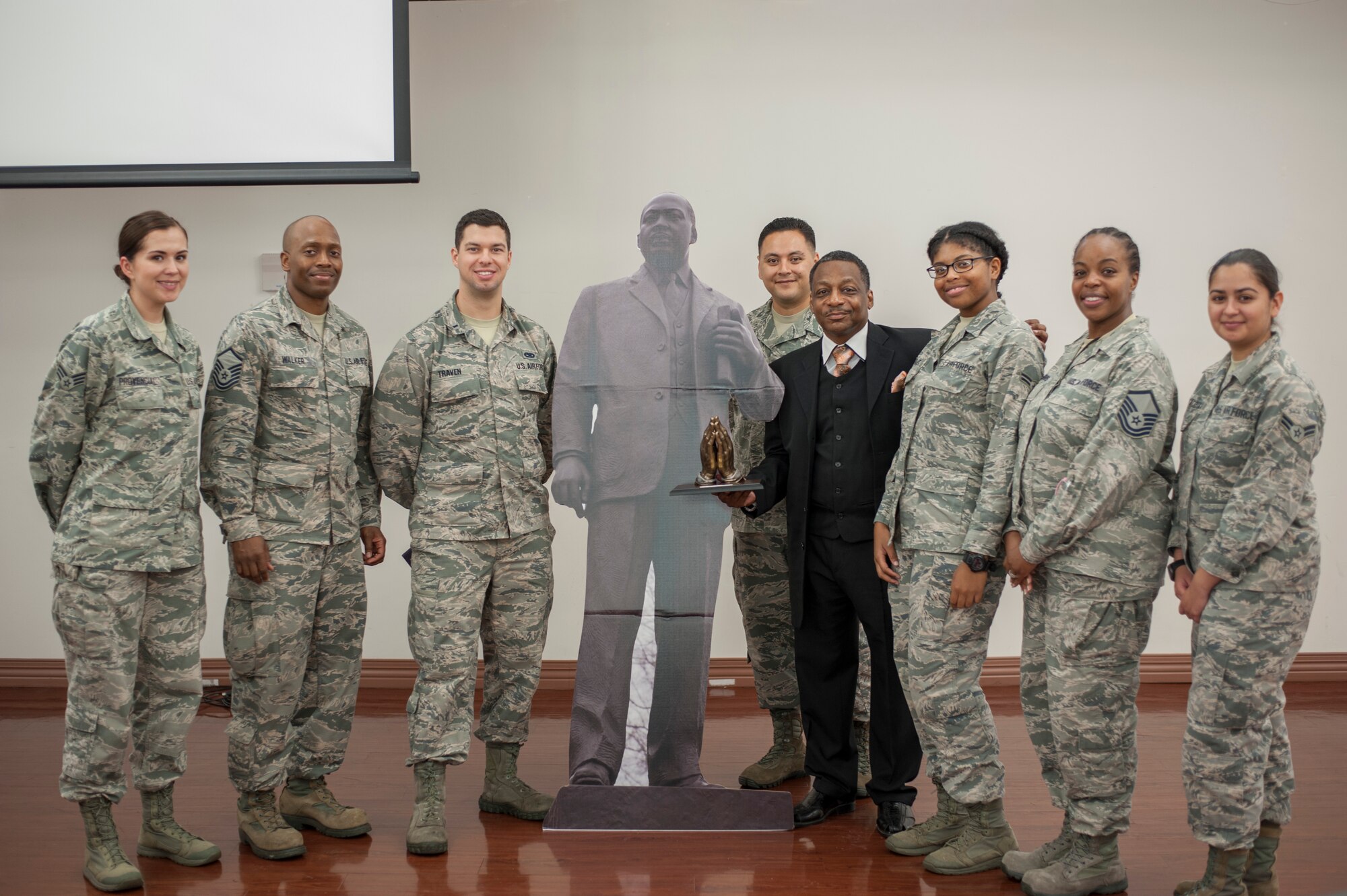 Members of the Dr. Martin Luther King Jr. committee and Anthony Brinkley, a retired chief master sergeant and inspirational speaker, pause for a photo with a display of King during an MLK observance luncheon at MacDill Air Force Base, Fla., Jan. 11, 2018.
