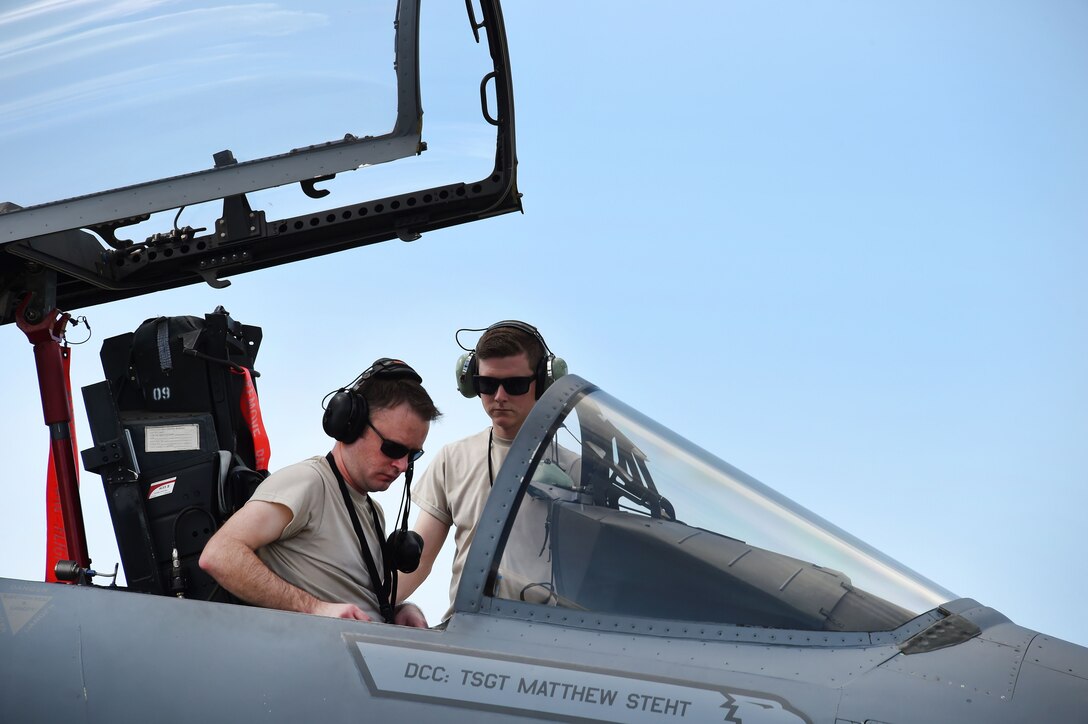 Air Force Staff Sgt. Steven Evans and Senior Airman Jeffrey Hughes perform post-flight checks on an F-15C Eagle fighter aircraft.