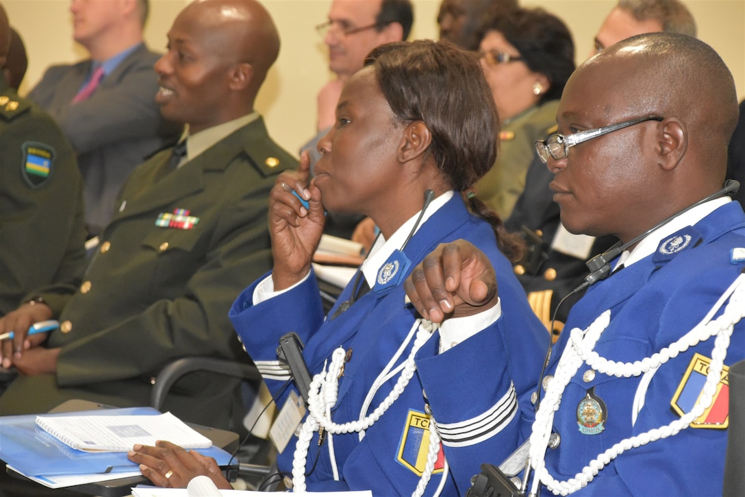 Two service members from Chad listen to a speech.