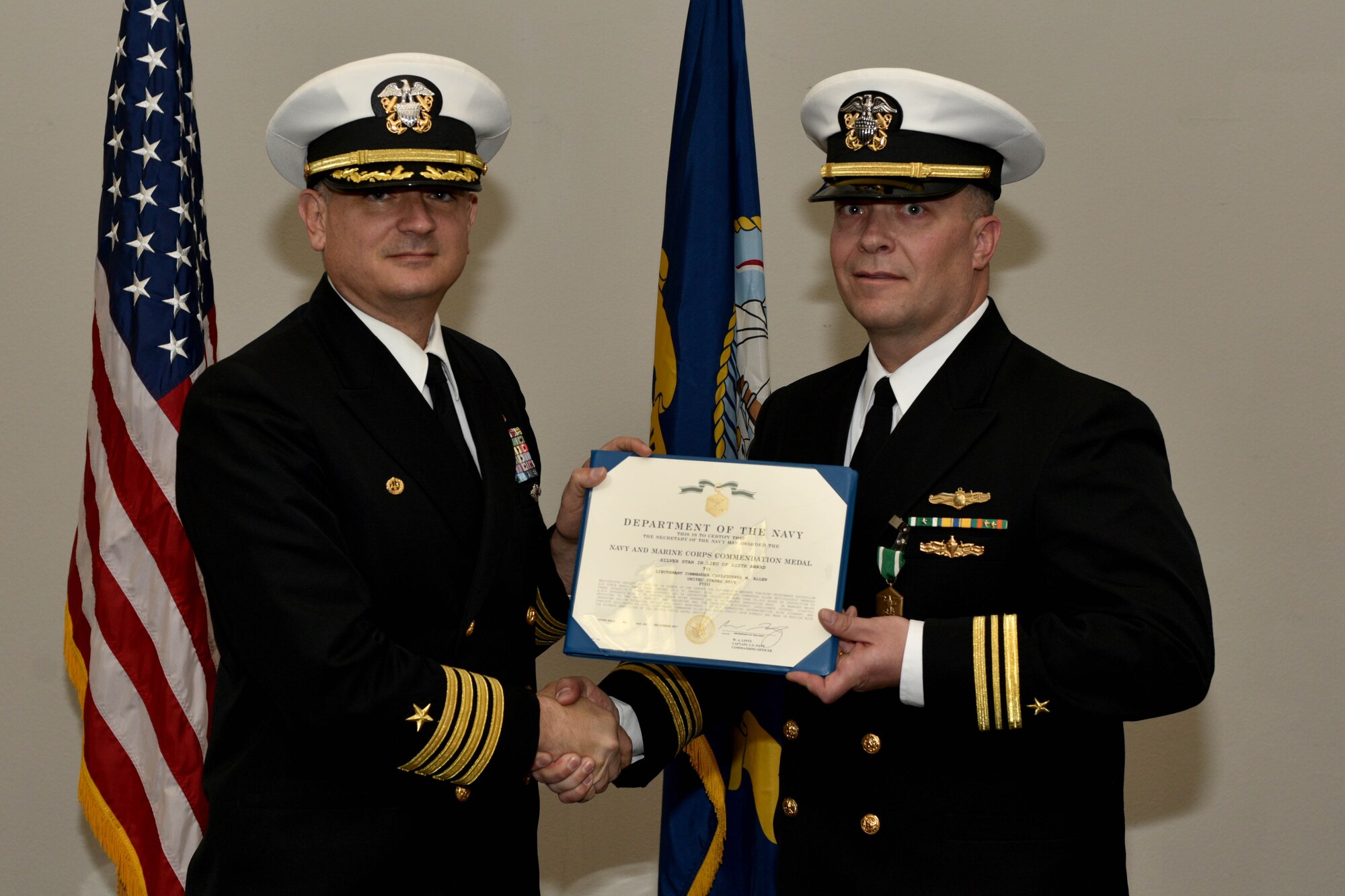 U.S. Navy Capt. William Lintz, Center for Information Warfare Training commanding officer, presents Lt. Cmdr. Christopher Allen, departing CIWT officer in charge, the Navy and Marine Corps Commendation medal during the change of charge ceremony at the Event Center on Goodfellow Air Force Base, Texas, Jan. 12, 2018. The Navy and Marine Corps Commendation medal may be awarded to those serving with the Navy or Marine Corps, who distinguish themselves by heroic or meritorious achievement or service. (U.S. Air Force photo by Senior Airman Randall Moose/released)