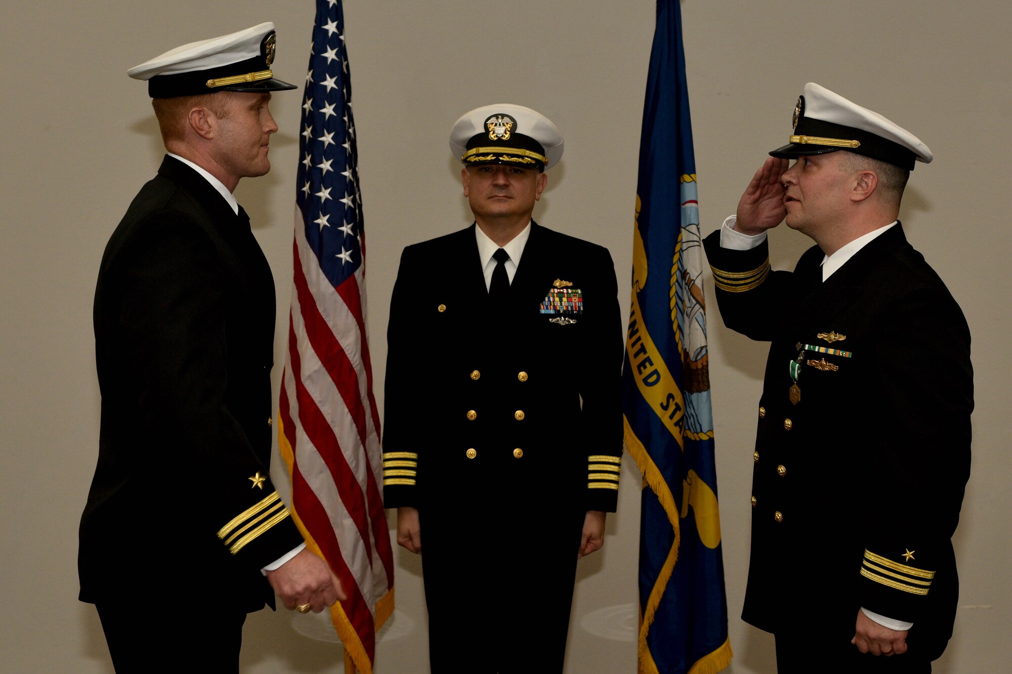 U.S Navy Lt. Cmdr. J. Austin Maxwell, Center for Information Warfare Training officer in charge, exchanges salutes with Capt. William Lintz, CIWT commanding officer, and Lt. Cmdr. Christopher Allen, departing CIWT officer in charge, during the change of charge ceremony at the Event Center on Goodfellow Air Force Base, Texas, Jan. 12, 2018. The change of charge ceremony is a time honored military tradition that signifies the orderly transfer of authority. (U.S. Air Force photo by Senior Airman Randall Moose/released)