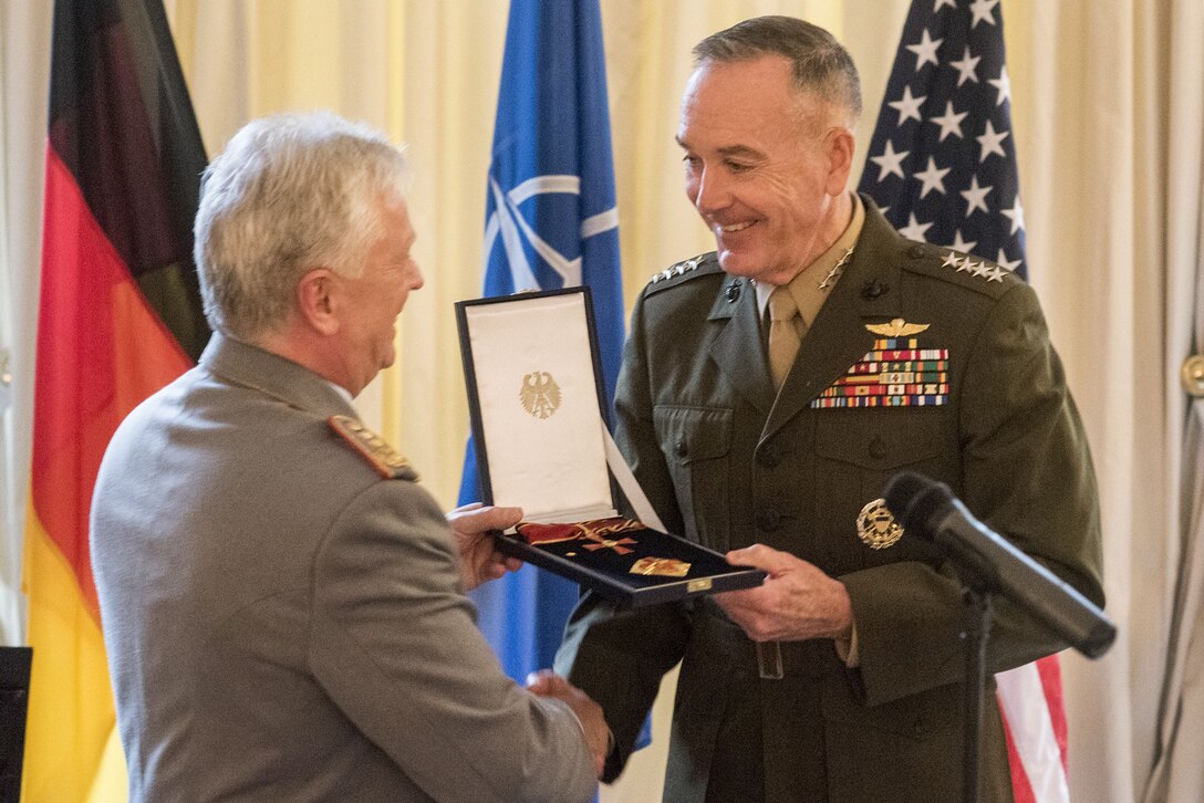 The chairman of the Joint Chiefs of Staff receives a German medal from his German counterpart in Brussels.