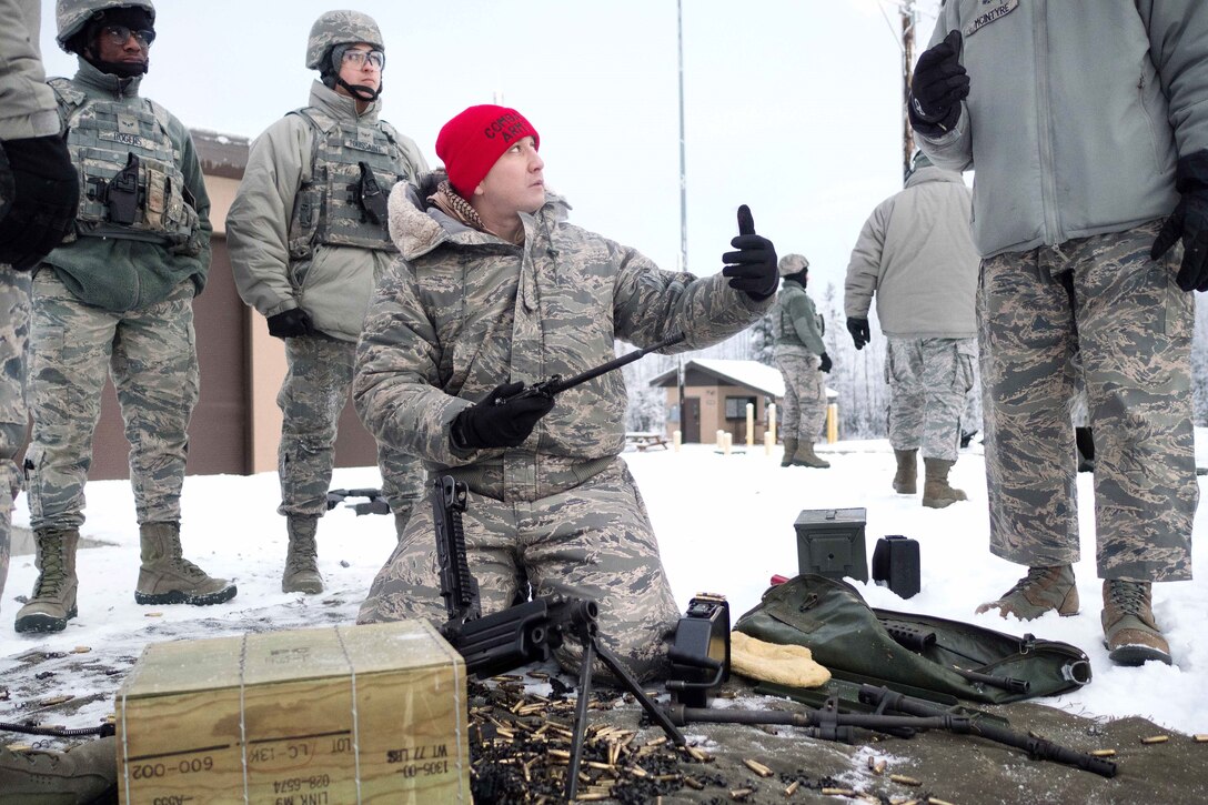 An airman demonstrates proper maintenance for an automatic weapon.