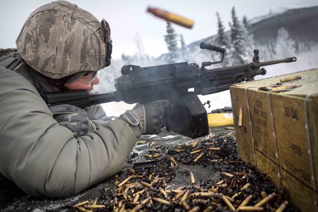 An airman fires at a target with an automatic weapon.