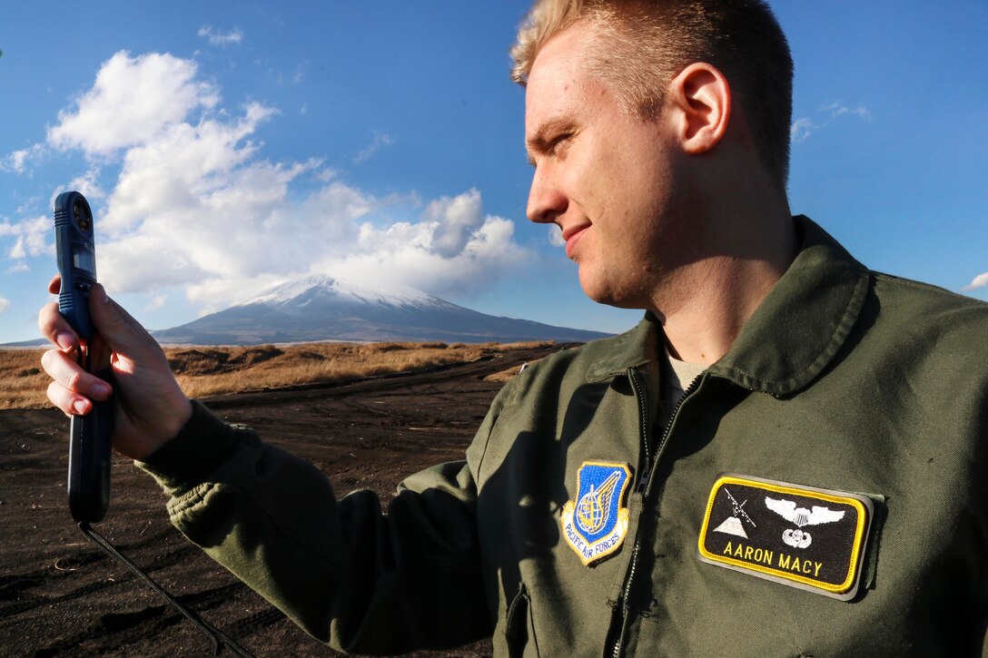 An airman holds an electronic instrument.