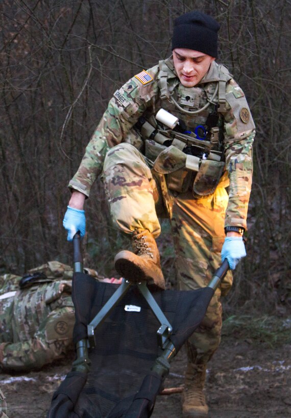 A soldier places his foot on a collapsible stretcher.