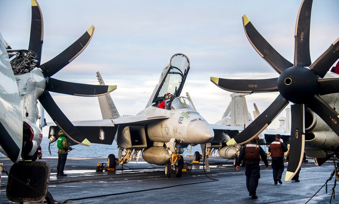 Sailors perform maintenance on an F/A-18F Super Hornet aircraft.