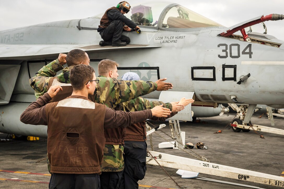 Sailors train on non-verbal signals on the Nimitz-class aircraft carrier USS Carl Vinson.