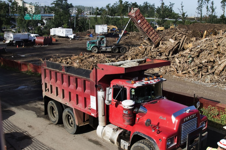 Trucks carrying vegetative debris from Hurricane Maria deposit their loads at the Los Alamos Temporary Debris Reduction Site (TDRS) in Guaynabo, Puerto Rico Jan. 10. The U.S. Army Corps of Engineers is leading the federal debris management mission as part of the Federal Emergency Management Agency's (FEMA) Hurricane Maria response effort. The USACE mission has collected more than 2 million cubic yards of hurricane debris in Puerto Rico to date. 

To get a sense of how much vegetative debris was created by Hurricane Maria, Peter Gibson, the USACE debris zone engineer for Zone 2, which includes Guaynabo, said locals told him the greenery before Hurricane Maria was so thick they couldn't see their neighbors. 

"After the storm hit, everything turned brown and they had a revelation of how many neighbors they had, because they could see them for the first time," he said. "All that debris, all the trees and all those sticks, they wound up on the ground, and they clog everything from roadways to waterways, so that's what we're out here trying to remove."