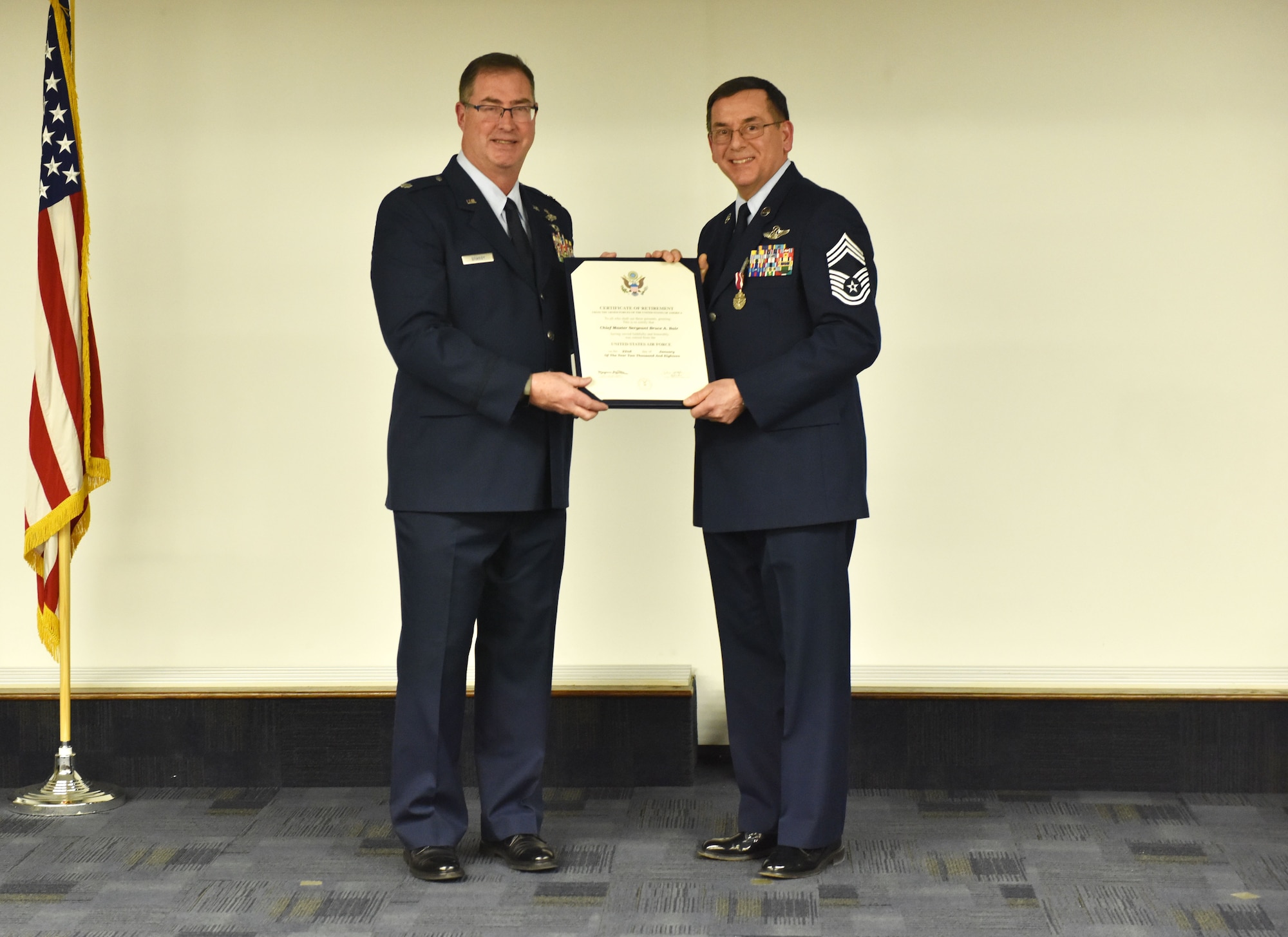 Lt. Col. Bryan Branby, 758th Airlift Squadron director of operations, presents Chief Master Sgt. Bruce Bair with a certificate of retirement during a ceremony at the Pittsburgh International Airport Air Reserve Station, Jan. 6, 2018. Bair is the last flight engineer to retire from the 911th Airlift Wing, departing the military after 38 years of faithful service. (U.S. Air Force photo by Staff Sgt. Marjorie A. Bowlden)