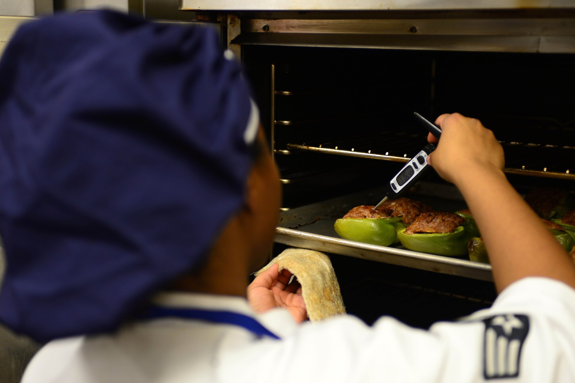 Senior Airman Caprice Walker, a food services journeyman assigned to the 28th Force Support Squadron, checks the temperature of stuffed peppers inside the Raider Café at Ellsworth Air Force Base, S.D., Jan. 11, 2018.
