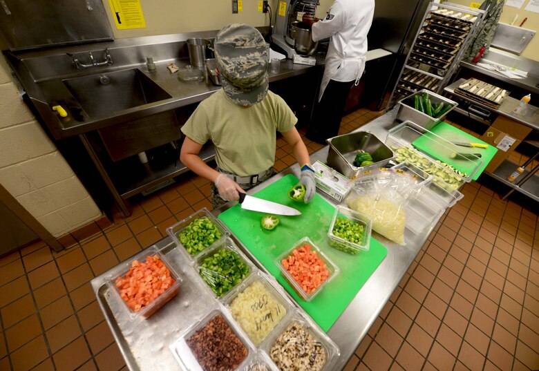 Airman 1st Class Claudine Batulan, a food services apprentice assigned to the 28th Force Support Squadron, slices green bell peppers for lunch inside the Raider Café at Ellsworth Air Force Base, S.D., Jan. 11, 2018.