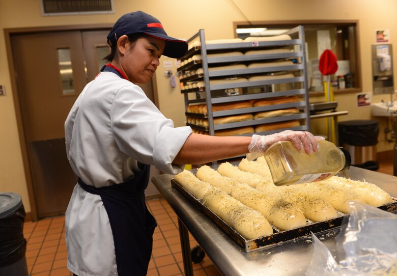 Jeranai Stolz, a deli chef assigned to the 28th Force Support Squadron, seasons loaves of bread inside the Raider Café at Ellsworth Air Force Base, S.D., Jan. 12, 2018.