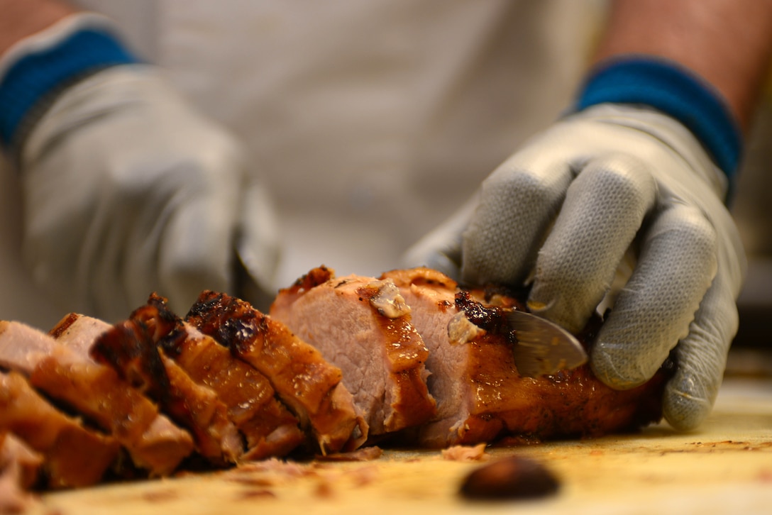 Staff Sgt. Patrick Fitch, a food services shift manager assigned to the 28th Force Support Squadron, slices and prepares pork inside the Raider Café at Ellsworth Air Force Base, S.D., Jan. 12, 2018.