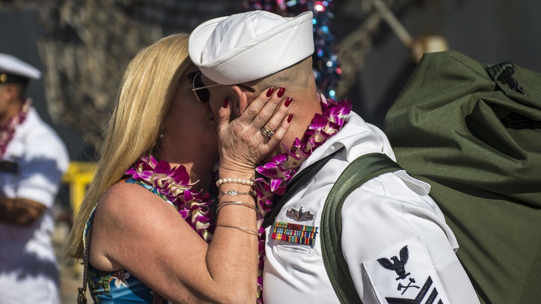 A sailor kisses his wife after returning from a deployment.