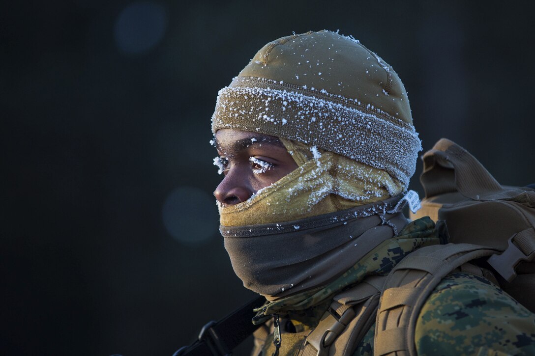 A Marine faces the cold as snow freezes to his eyelashes.