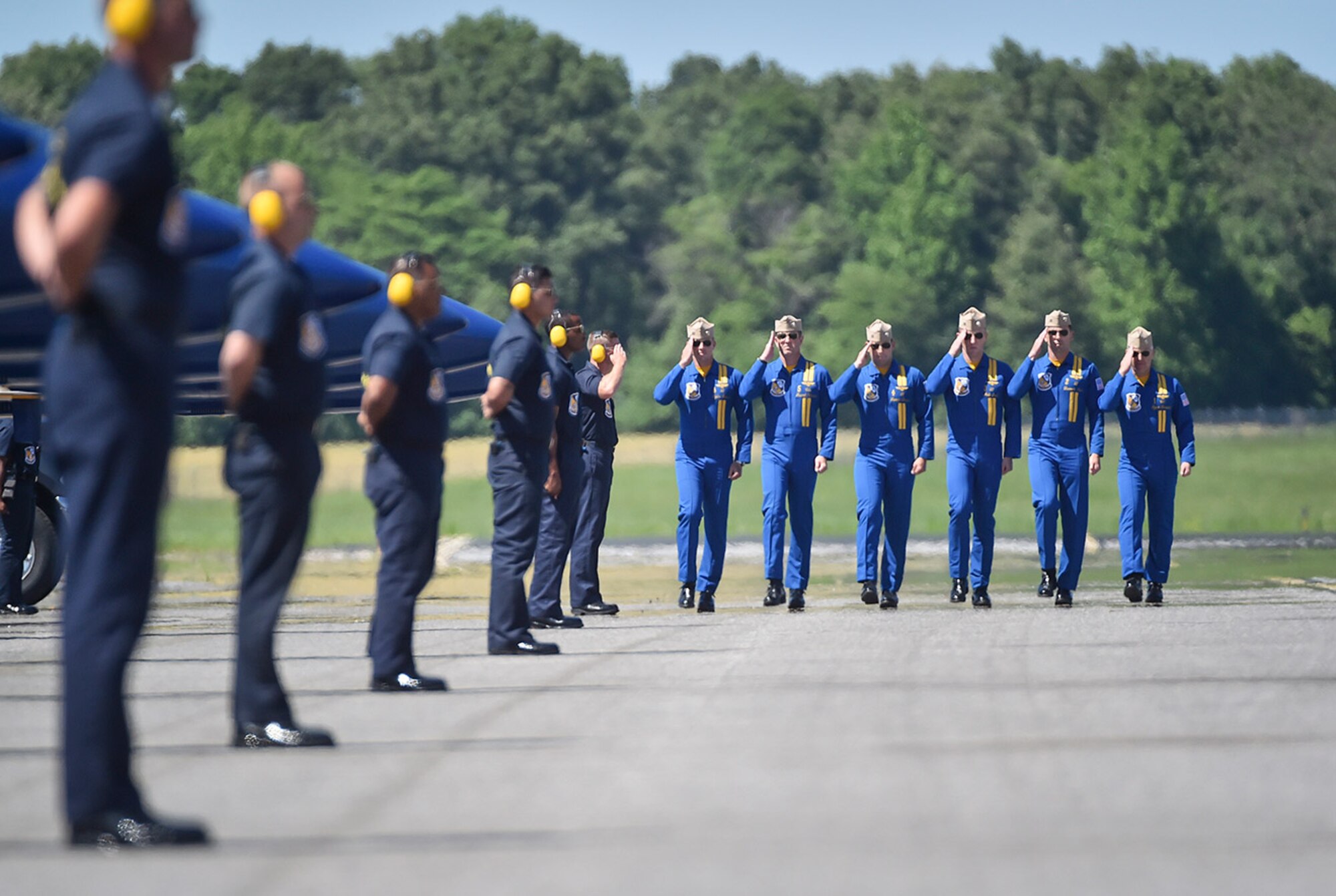 The U.S. Navy's Blue Angels pilots march six abreast as they greet their crew chiefs prior to getting in their jets.  The Blue Angels are the Navy's premiere aerial demonstration team performing at air shows around the world.