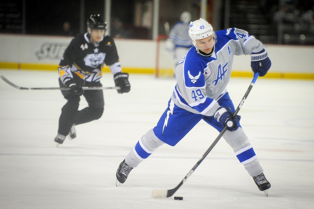 An airman prepares to fire the puck at the opponents net during the 5th Annual Army vs. Air Force Hockey game.