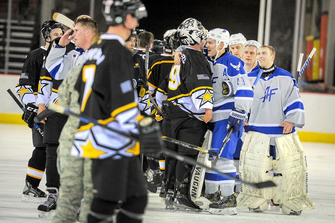 Airmen and soldiers shake hands and congratulate each other after competing in the 5th annual Army vs. Air Force hockey game.