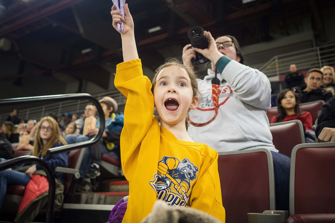 A young hockey fan cheers on her favorite team.
