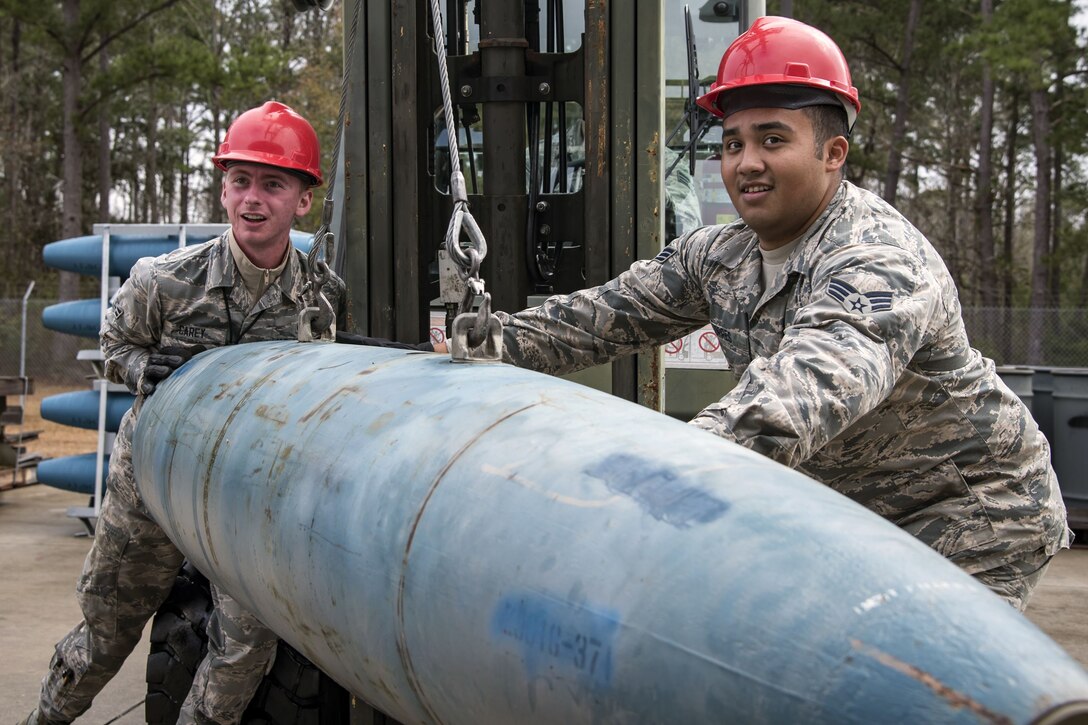 Airman 1st Class Colten Carey, 23d Maintenance Squadron (MXS) precision guided munitions technician, left, and  Airman 1st Class Jordon Torres, 23d MXS munitions specialist, rotates a Joint Direct Attack Munition, Jan. 11, 2018, at Moody Air Force Base, Ga. The 23d MXS held a combat munitions class to help acclimate and improve their Airmen’s readiness to perform well in a deployed environment.  (U.S. Air Force photo by Airman Eugene Oliver)