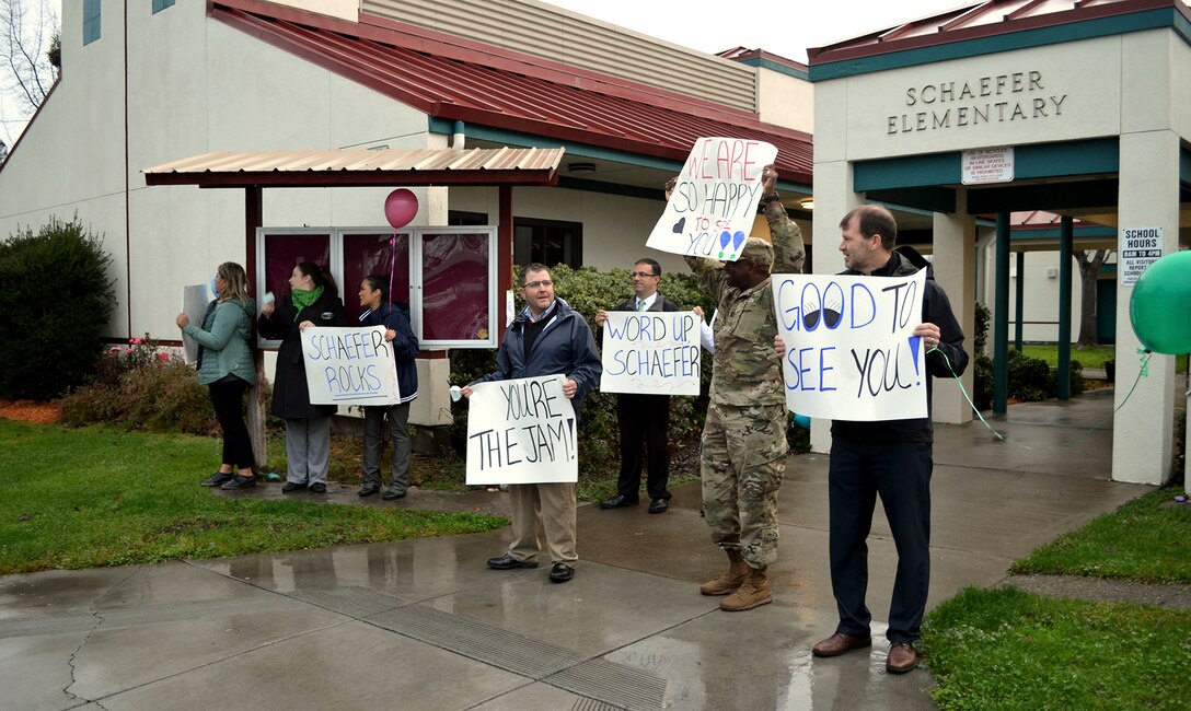 Schaefer Elementary School staff, first responders and community leaders all waive signs welcoming students back to school after a three-month absence as a result of the October 2017 wildfires that swept through the Coffey Park community.