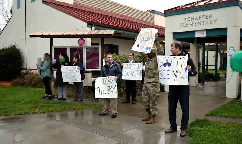 Schaefer Elementary School staff, first responders and community leaders all waive signs welcoming students back to school after a three-month absence as a result of the October 2017 wildfires that swept through the Coffey Park community.