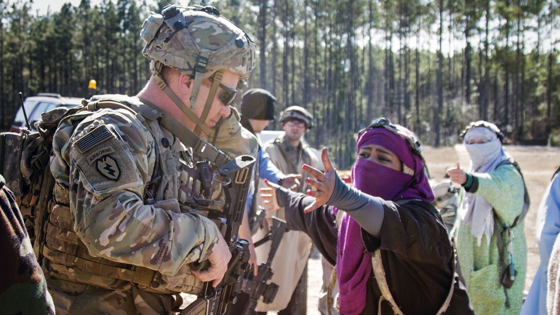 A soldier interacts with a woman playing the role of an Afghan citizen.