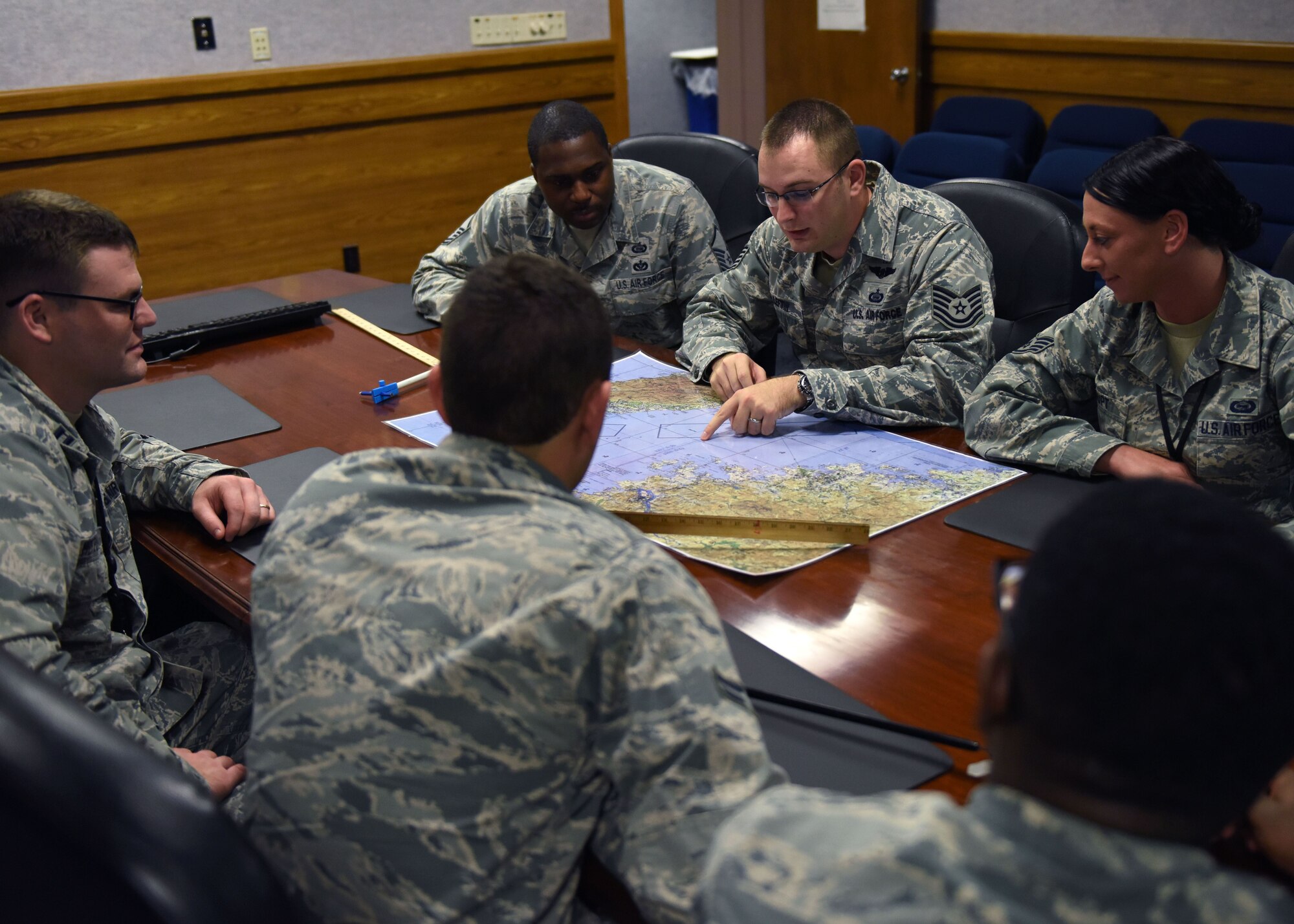 U.S. Air Force Airmen from the 325th Operations Support Squadron intelligence flight examine a map during an unclassified briefing at Tyndall Air Force Base, Fla., Oct. 25, 2017. The 325th OSS intel flight works behind the scenes analyzing and assessing information then disseminating the pertinent information to allow for better decision making. (U.S. Air Force photo by Airman 1st Class Isaiah J. Soliz/Released)