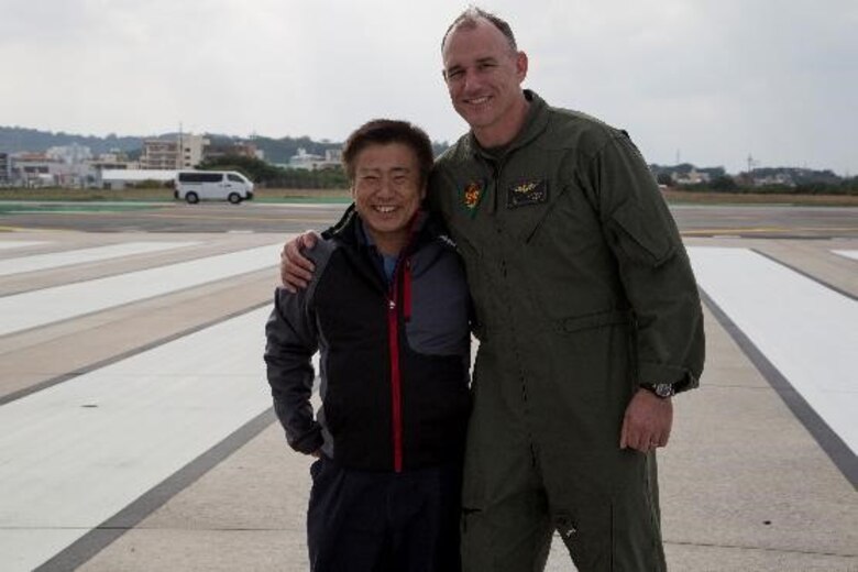 A member of the local community pose for a photo with Col. Mark Coppess