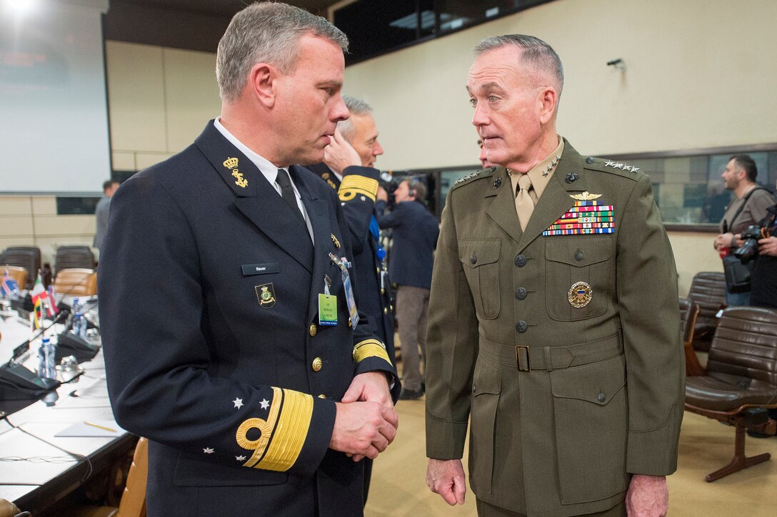 The chairman of the Joint Chiefs of Staff converses with one of his European counterparts at a NATO meeting.