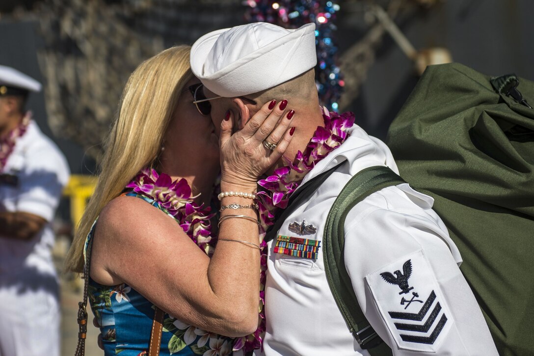 A sailor kisses his wife after returning from a deployment.